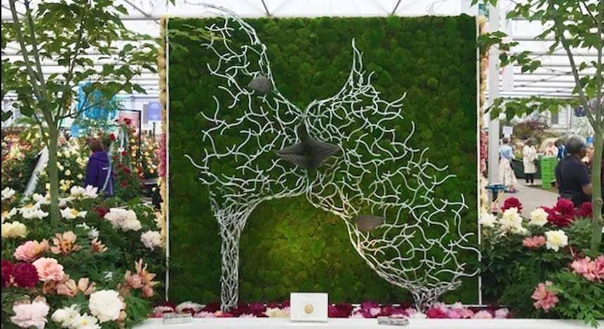 Bird Sculpture Against Green Moss