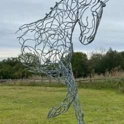 large half horse sculpture standing on black plinth