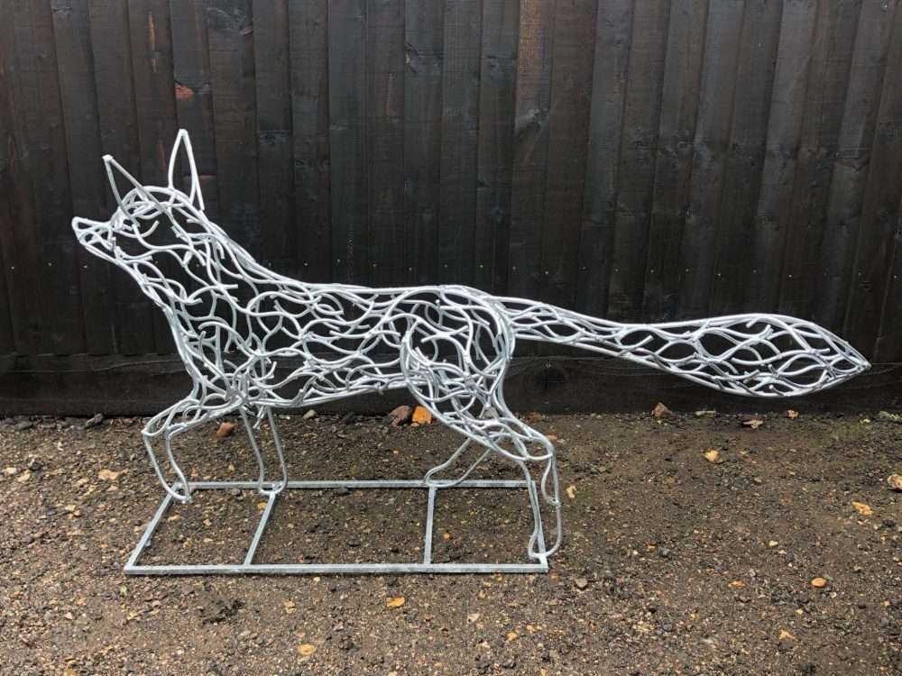 Galvanised Fox Sculpture Next To Wall