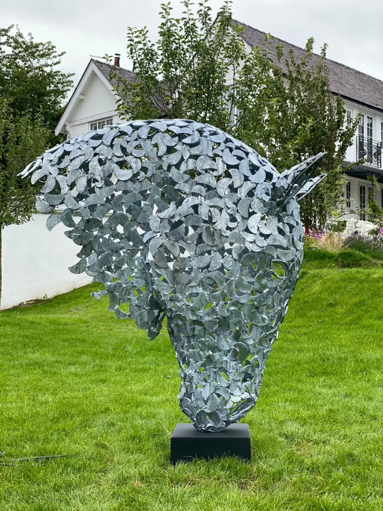 large silver horse head sculpture in a domestic garden