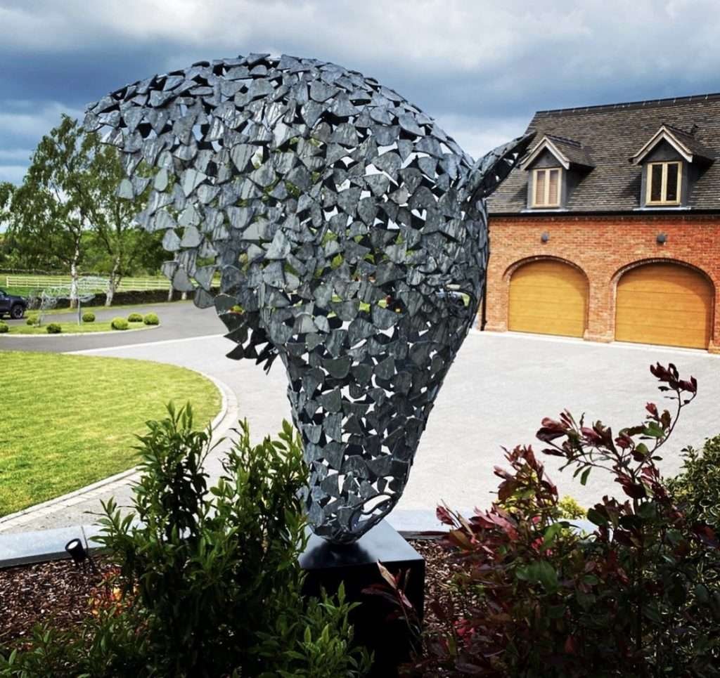 silver horse head sculpture mounted in front of a house