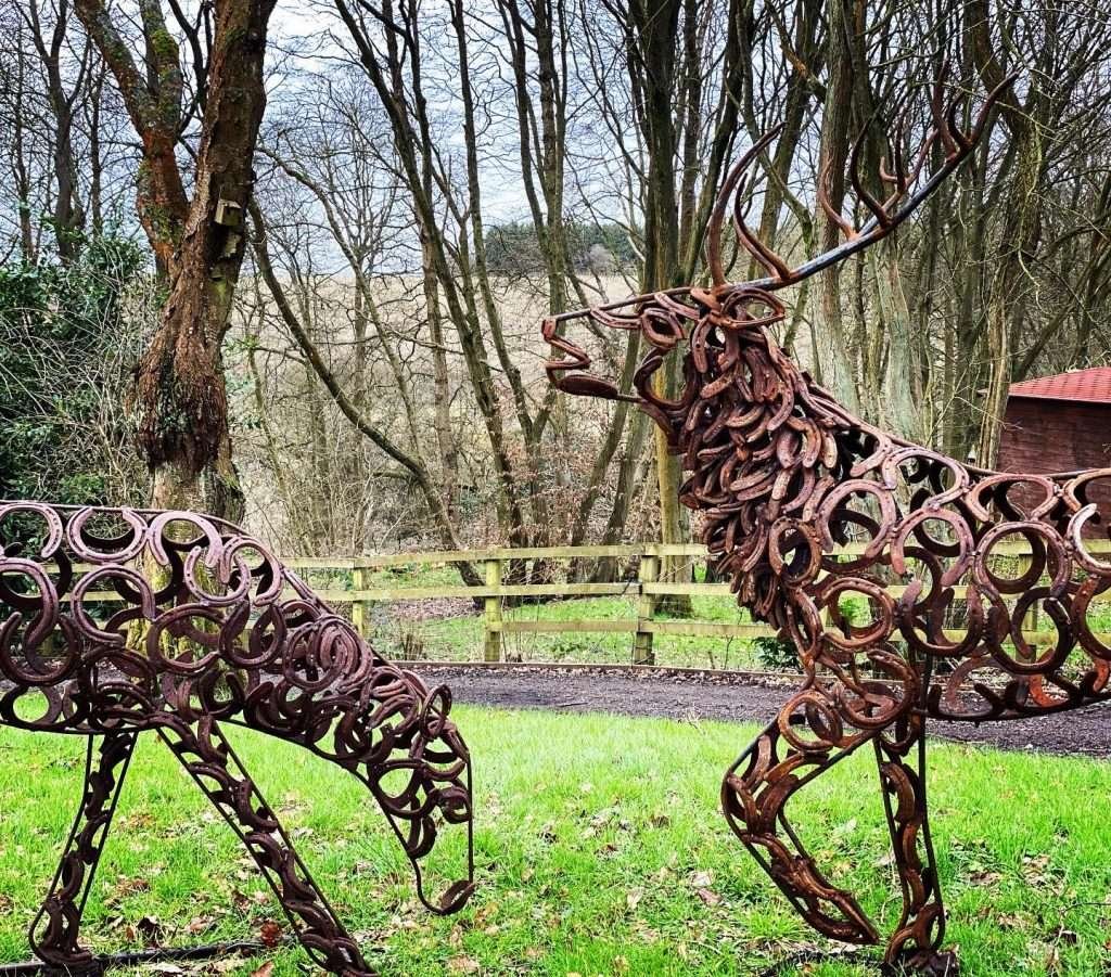 Two Stag Sculptures In A Field