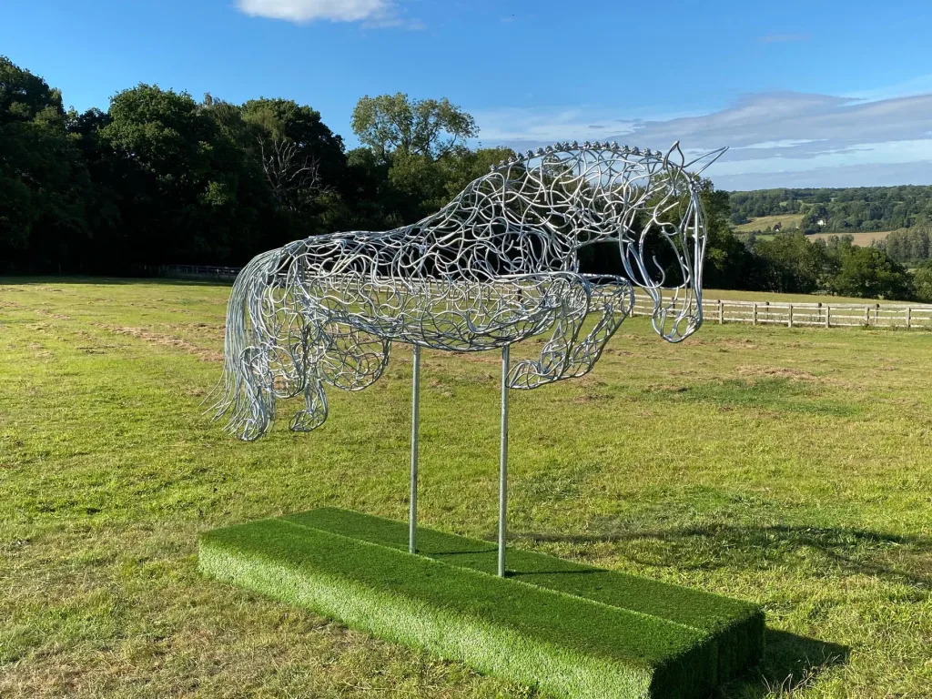 Silver Horse Sculpture In Large Field