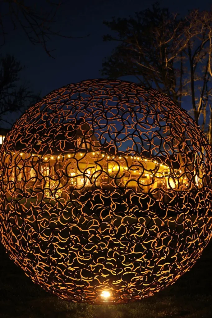 large bronze sphere sculpture at night