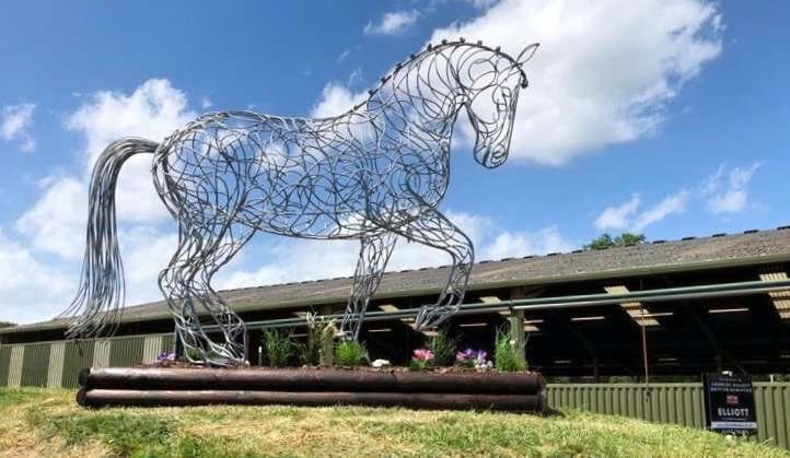 side view of a silver horse walking sculpture
