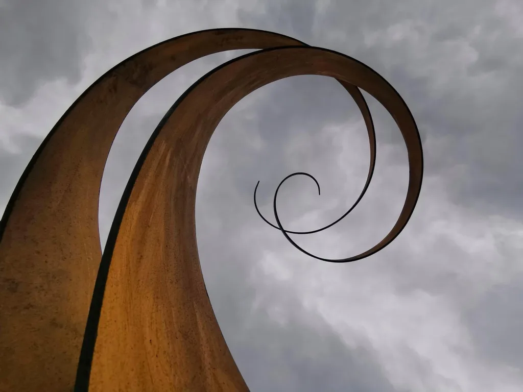 Large Curved Sculpture In Front Of A Cloudy Sky