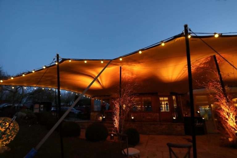 a lit up tent over a porch