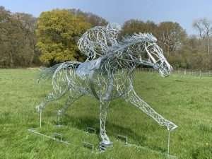 jockey and horse sculpture in field